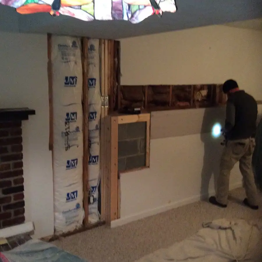 Restoration technician inspecting water damage in Grafton